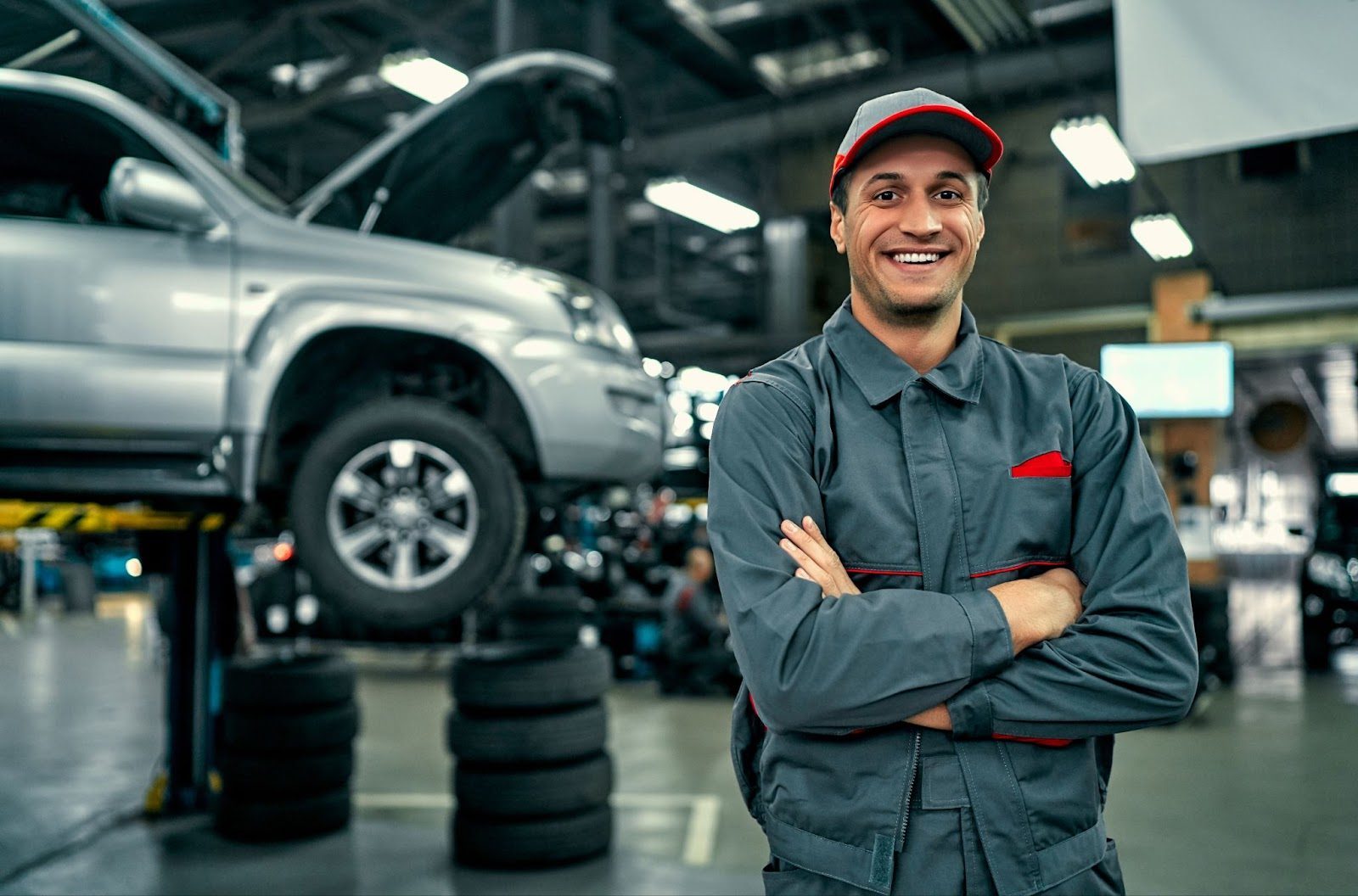Mechanic with a clipboard inspecting a used car on a lift at an independent repair shop